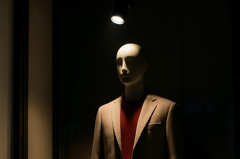 A focused spotlight on a mannequin in a store window, making it stand out from the surroundings.