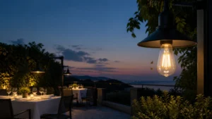 Conceptual restaurant terrace at dusk with warm decorative lighting and two insects near an exposed filament bulb