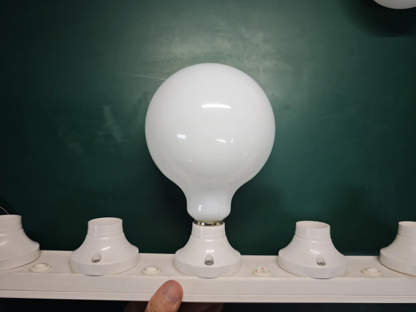 Unlit HongYu opal globe showing sharp reflected lights on its glossy white surface